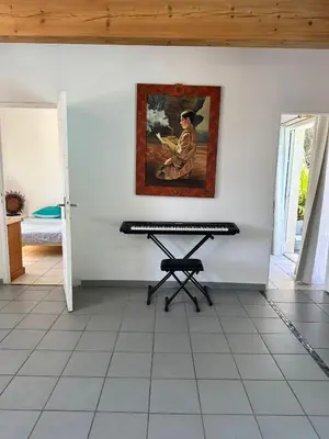 a piano in a room with a painting on the wall at maison de rêve dans un écrin de verdure au calme in Eccica-Suarella