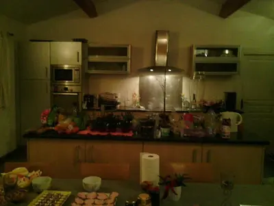 a kitchen with a table and a counter top at maison de rêve dans un écrin de verdure au calme in Eccica-Suarella