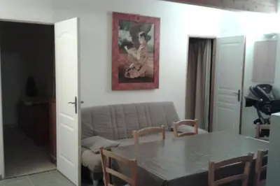 a living room with a table and a couch at maison de rêve dans un écrin de verdure au calme in Eccica-Suarella
