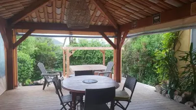 a patio with a table and chairs on a wooden deck at A VIGNA VECCHIA chambre d'hôtes in Porto-Vecchio