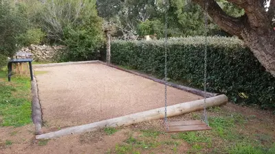 a playground with a wooden log and a swing at A VIGNA VECCHIA chambre d'hôtes in Porto-Vecchio