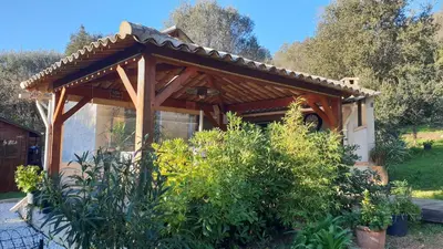 a wooden pergola in a garden with plants at A VIGNA VECCHIA chambre d'hôtes in Porto-Vecchio