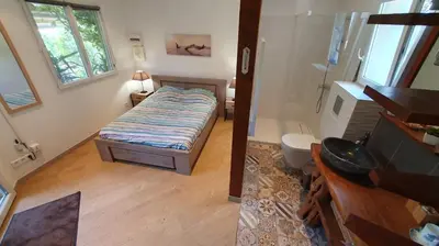 a small bedroom with a bed and a bathroom at A VIGNA VECCHIA chambre d'hôtes in Porto-Vecchio