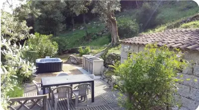 a patio with a table and chairs and a heater at Gîte au coeur d'une oliveraie in Sartène
