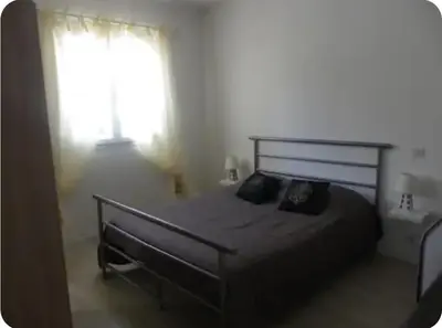 a bedroom with a large bed and a window at Gîte au coeur d'une oliveraie in Sartène