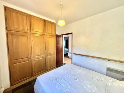 a bedroom with a bed and wooden cabinets at Appartement Golfe de Lava in Appietto