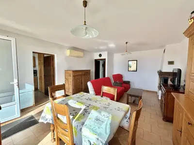 a living room with a table and a couch and a table and chairs at Appartement Golfe de Lava in Appietto