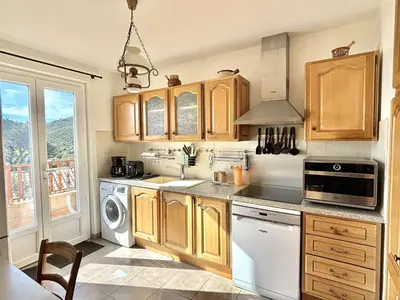 a kitchen with wooden cabinets and white appliances at Appartement Golfe de Lava in Appietto