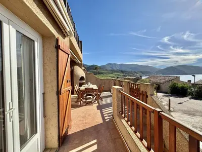a balcony with a table and a view of the water at Appartement Golfe de Lava in Appietto
