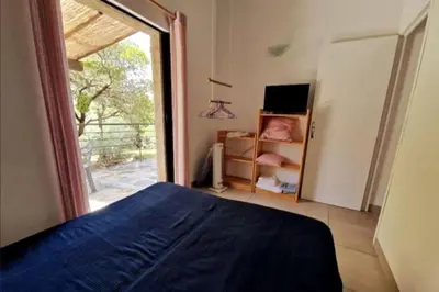 a bedroom with a bed and a large window at Petit nid douillet à deux pas de Santa Giulia in Porto-Vecchio