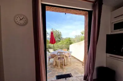 a view of a table and chairs on a patio at Petit nid douillet à deux pas de Santa Giulia in Porto-Vecchio
