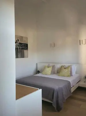 a bedroom with a large bed with yellow pillows at Appartement fonctionnel 4p avec piscine et vue mer in Porto-Vecchio