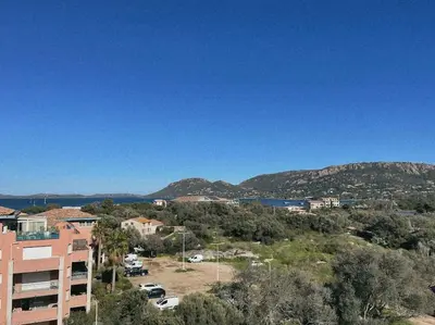 a view of a city with mountains in the background at Appartement fonctionnel 4p avec piscine et vue mer in Porto-Vecchio