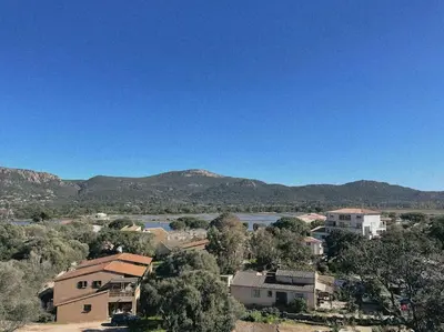 a view of a town with a river and mountains at Appartement fonctionnel 4p avec piscine et vue mer in Porto-Vecchio