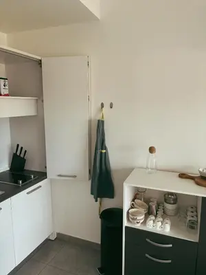 a kitchen with a white door and a black cabinet at Appartement fonctionnel 4p avec piscine et vue mer in Porto-Vecchio