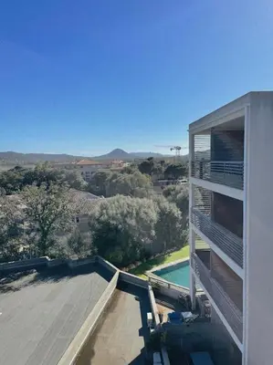 a view of a house with a swimming pool at Appartement fonctionnel 4p avec piscine et vue mer in Porto-Vecchio