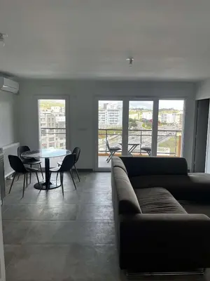 a living room with a couch and a table at Très beau T2 in Ajaccio