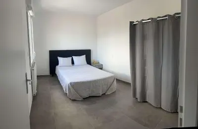 a bedroom with a bed and a shower curtain at Très beau T2 in Ajaccio