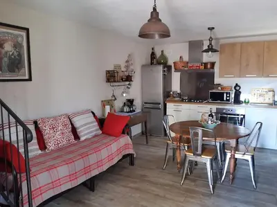 a living room with a couch and a table and a kitchen at Maison de charme Orezza Haute-Corse Castagniccia in Carpineto