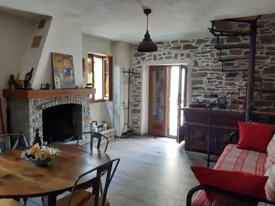 a living room with a table and a fireplace at Maison de charme Orezza Haute-Corse Castagniccia in Carpineto