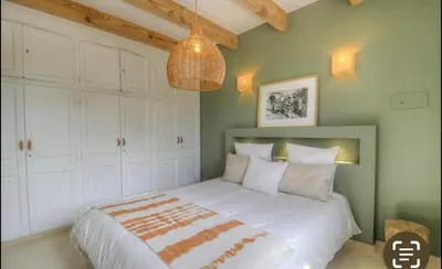 a bedroom with a large white bed with a chandelier at CASA BIANCA 6 personnes Piscine Chauffée in Bonifacio