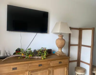 a flat screen tv on top of a dresser with a lamp at Piana - vue mer et village in Piana