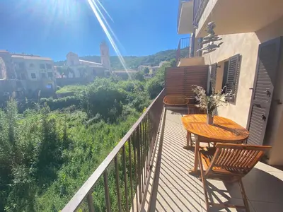 a balcony with a table and chairs on a balcony at Piana - vue mer et village in Piana