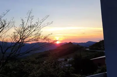 a sunset with the sun setting on a mountain at Appartement F2 dessous de villa in Olmeta-di-Tuda