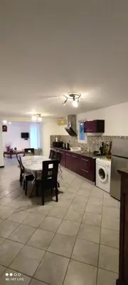 a kitchen with a table and some chairs and a kitchen with a table at Appartement F2 dessous de villa in Olmeta-di-Tuda