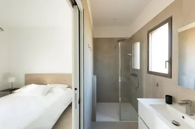 a bathroom with a bed and a shower and a sink at Villa avec piscine in Ghisonaccia
