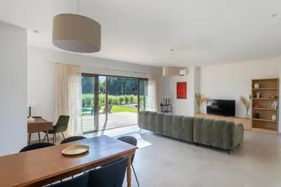 a living room with a couch and a table at Villa avec piscine in Ghisonaccia