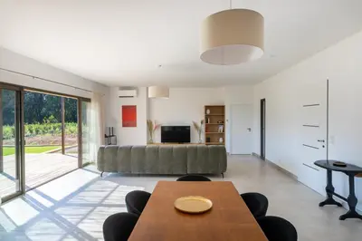 a living room with a couch and a table at Villa avec piscine in Ghisonaccia