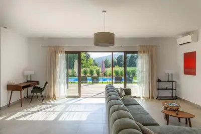 a living room with a couch and a table at Villa avec piscine in Ghisonaccia