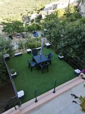 a patio with a table and chairs on the grass at Studio neuf à 15mn de la mer in Occhiatana