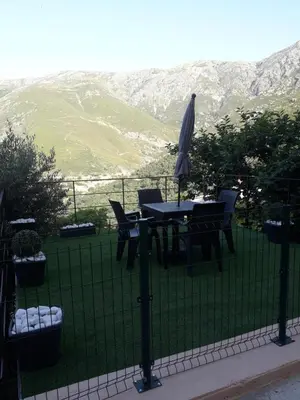 a table and chairs with an umbrella on a lawn at Studio neuf à 15mn de la mer in Occhiatana