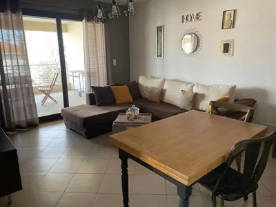 a living room with a couch and a table at Bel Appartement en plein cœur de Folelli in Penta-di-Casinca
