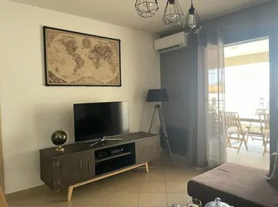 a living room with a flat screen tv and a couch at Bel Appartement en plein cœur de Folelli in Penta-di-Casinca