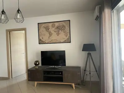 a living room with a flat screen tv on a wall at Bel Appartement en plein cœur de Folelli in Penta-di-Casinca