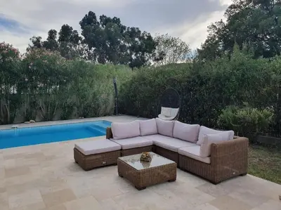 a couch sitting on a patio next to a pool at Maison à Saint-Florent avec piscine privée in Oletta