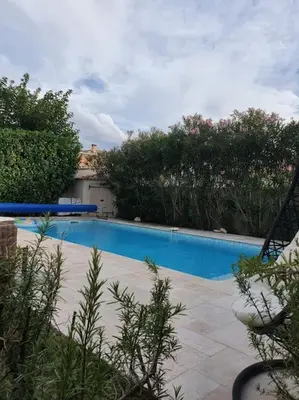 a large blue swimming pool in a yard at Maison à Saint-Florent avec piscine privée in Oletta