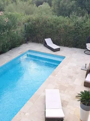 a swimming pool with two lounge chairs next to it at Maison à Saint-Florent avec piscine privée in Oletta