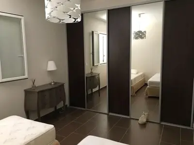 a room with a mirror and a bedroom with two beds at Maison à Saint-Florent avec piscine privée in Oletta