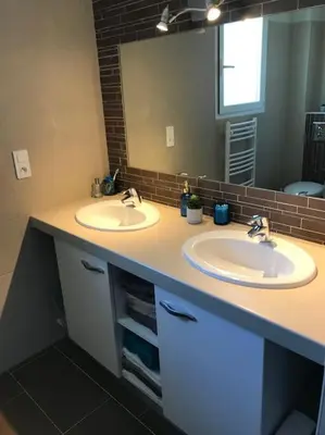 a bathroom with two sinks and a large mirror at Maison à Saint-Florent avec piscine privée in Oletta