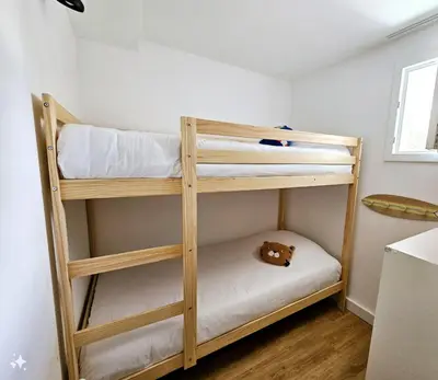 two bunk beds in a room with a teddy bear at Très bel appartement T3 dans résidence hotellière 