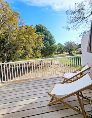 a lounge chair on a wooden deck with a fence at Très bel appartement T3 dans résidence hotellière 