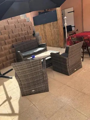 three wicker chairs and a table with an umbrella at Chez Aldo in Ajaccio
