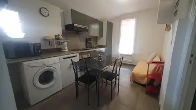 a kitchen with a table and a washing machine at Chez Aldo in Ajaccio