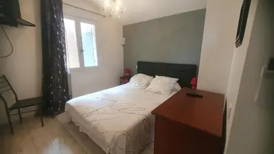 a bedroom with a bed and a desk and a window at Chez Aldo in Ajaccio