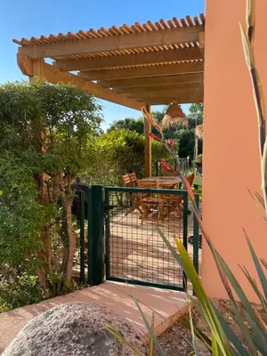 a patio with a fence and a table and chairs at Villa A CASA DI LO in Lecci