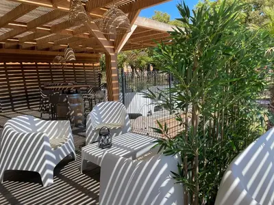 a patio with white chairs and a tree at Villa A CASA DI LO in Lecci